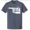 True Heather Navy t-shirt with the shape of Oklahoma design on chest. Graphic design also says "Oklahoma" where the second "o" is the state shield. Also features a scissor tailed flycatcher. New Era logo is visible on the left sleeve; New Era tag is on the bottom front of shirt.